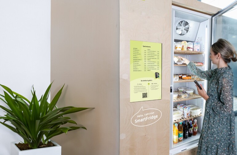 Frau entnimmt Essen aus Smartfridge