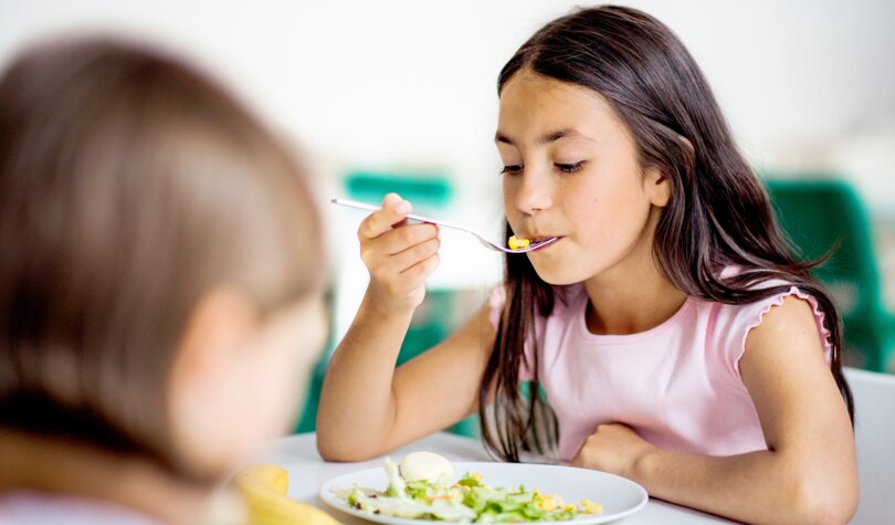 Schulmädchen isst Mittagessen