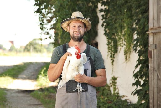Bauer vom Geflügelhof Locking hält Huhn in der Hand