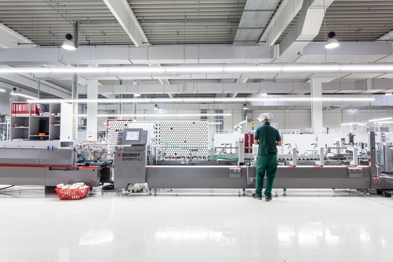 Produktionshalle mit Mitarbeitenden