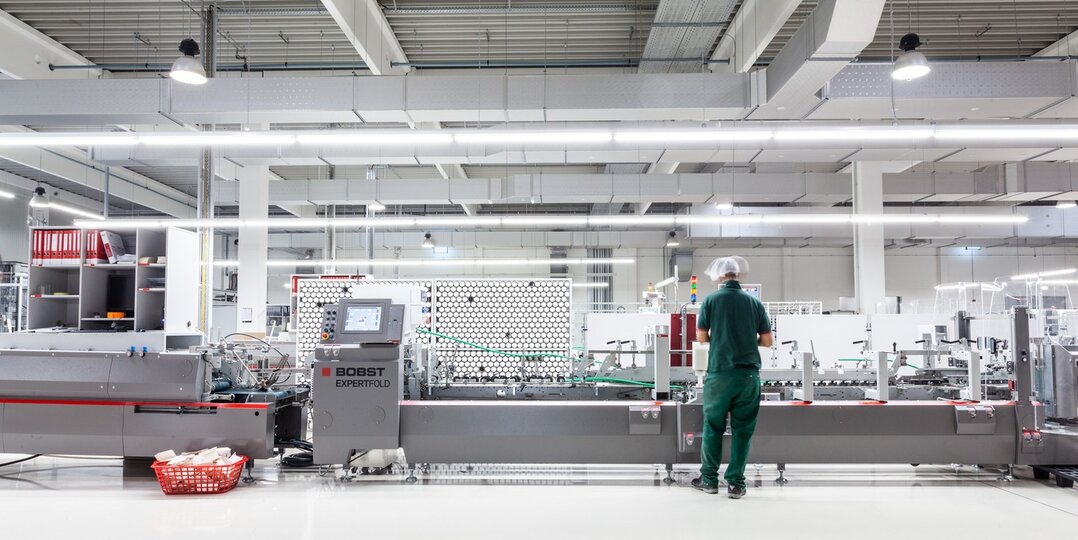 Produktionshalle mit Mitarbeitenden