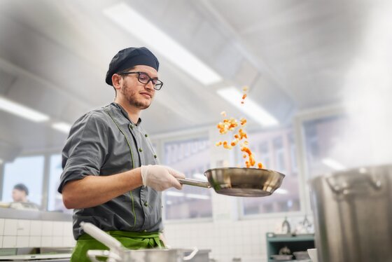 Koch schwenkt Pfanne