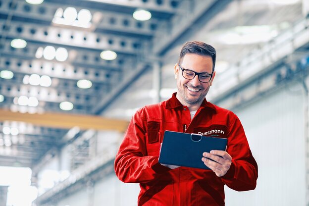 Ein Techniker von Dussmann während seiner Arbeit mit einem Klemmbrett in der Hand.  | © Dussmann 