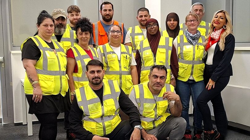 Frauen und Männer mit gelben Westen vom Team Gebäudereinigung von Dussmann | © Dussmann